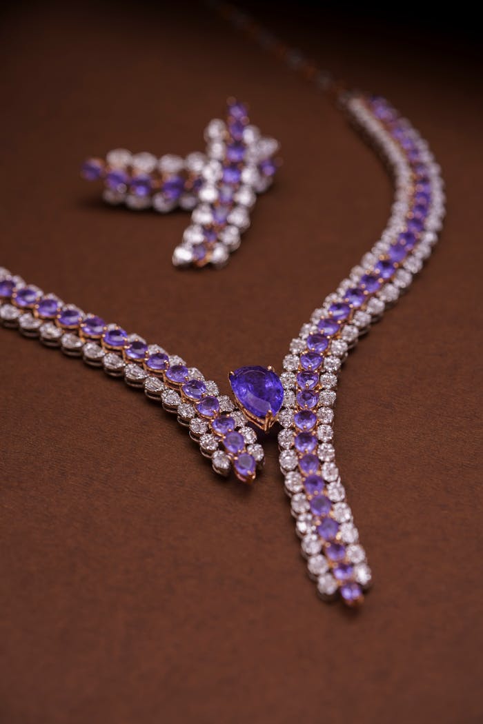 services-04 Luxury amethyst and diamond necklace and earring set on brown background.
