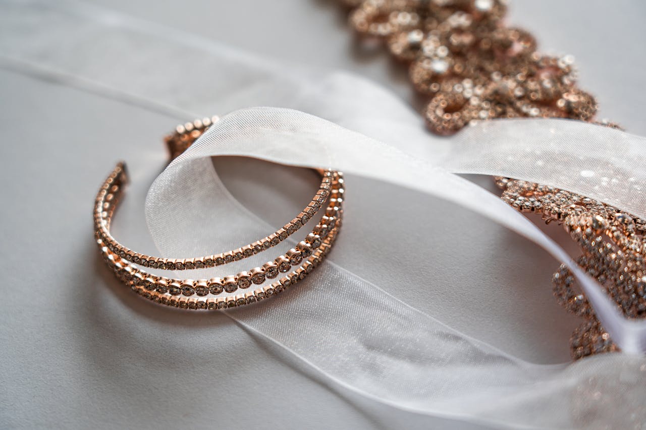 services-01 Close-up of luxurious rose gold jewelry on a sheer satin fabric, perfect for bridal occasions.